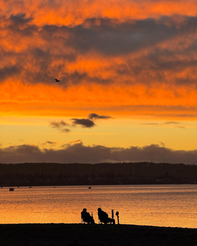 2 people watching sunset from English Bay