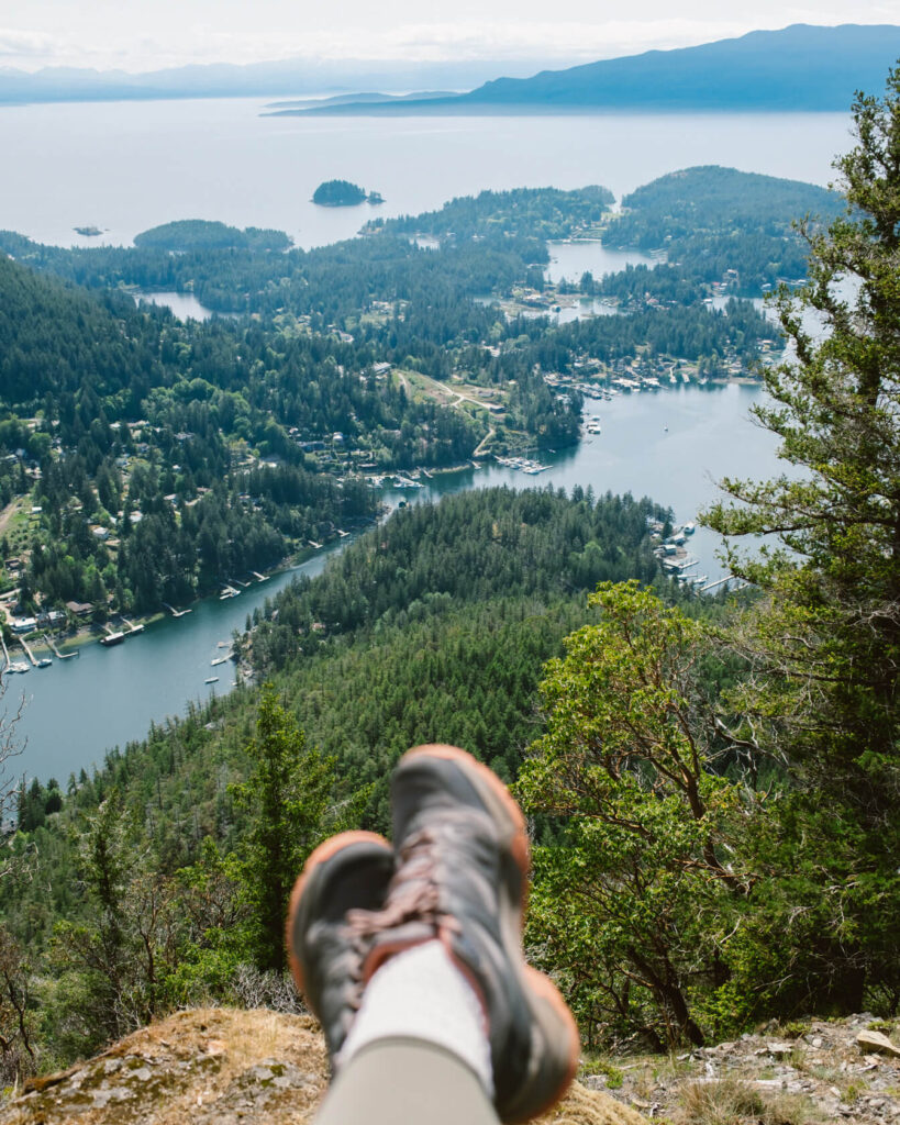 Close-up of hiking boots with Pender Harbour in the background